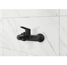 Černá sprchová baterie na bílé mramorové zdi