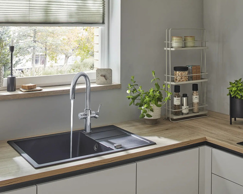 Kuchyňský dřez s kohoutkem ve světlé kuchyni.