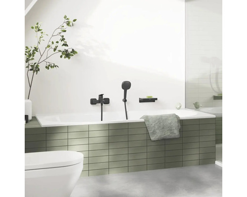 Koupelna s vanou, baterií, ruční sprchou, poličkou a ručníkem