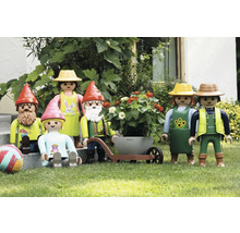 Scéna s zahradními figurkami Playmobil, včetně zahradních trpaslíků, páru s kolečkem a dítěte na trávníku