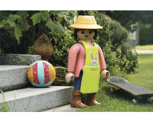Scéna s figurkou Playmobil, míčem a skateboardem na zahradě