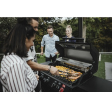 Skupina lidí griluje krevety na plynovém grilu venku