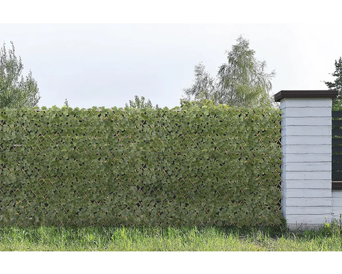 Zástěna se syntetickými listy jako dekorace a ochrana proti větru na zahradě.