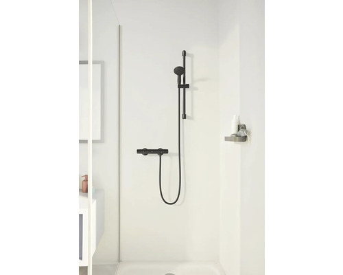 Sprchová armatura s tyčí a poličkou v koupelně.