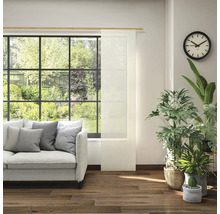 Obývací pokoj s pohovkou, pokojovými rostlinami, hodinami a posuvným panelem v okně