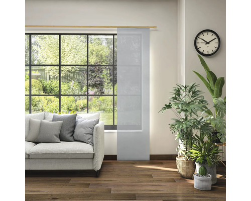 Obývací pokoj s posuvným panelem, pohovkou, hodinami a pokojovými rostlinami