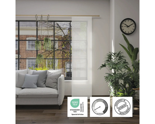 Obývací pokoj s pohovkou a průhledným panelovým závěsem s pečetí Öko-Tex Standard 100, symbolem průhlednosti a pečetí Designed in Germany.