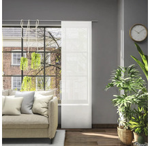 Obývací pokoj s pohovkou, pokojovými rostlinami a posuvnou záclonou před oknem