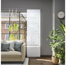 Obývací pokoj s pohovkou a průhledným posuvným závěsem v okně pro regulaci světla.