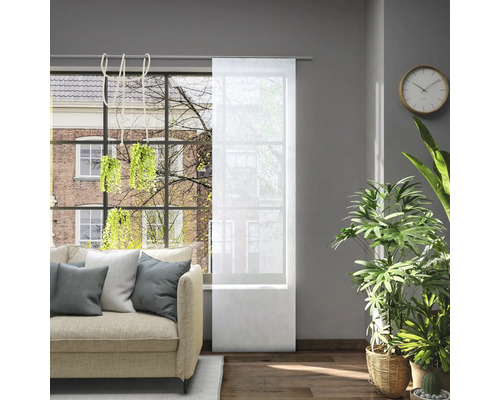 Obývací pokoj s pohovkou a průhledným posuvným závěsem v okně pro regulaci světla.
