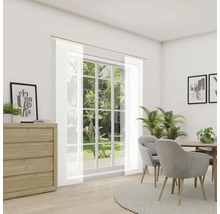 Světlá místnost s jídelním stolem, židlemi a okny s průhlednými závěsy