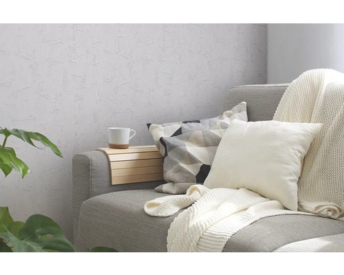 Šedá pohovka s polštáři, dekou a odkládacím stolkem v obývacím pokoji