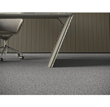 Detailní pohled na šedý koberec v kanceláři se stolem a kancelářskou židlí.