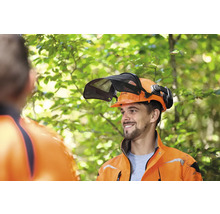 Lesník s lesnickou helmou s hledím a chrániči sluchu od společnosti Stihl