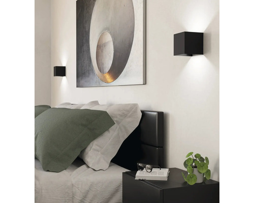Ložnice s postelí, nočním stolkem, nástěnnými svítidly a obrazem