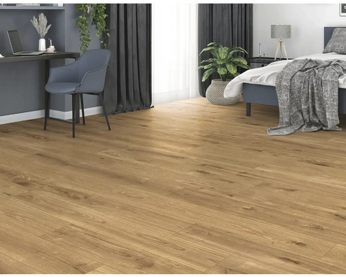 Světlá místnost s laminátovou podlahou, postelí a psacím stolem.