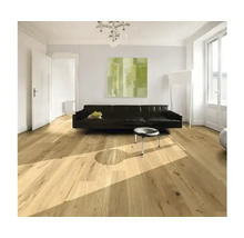 Světlý obývací pokoj s dřevěnou podlahou, pohovkou a uměleckým dílem