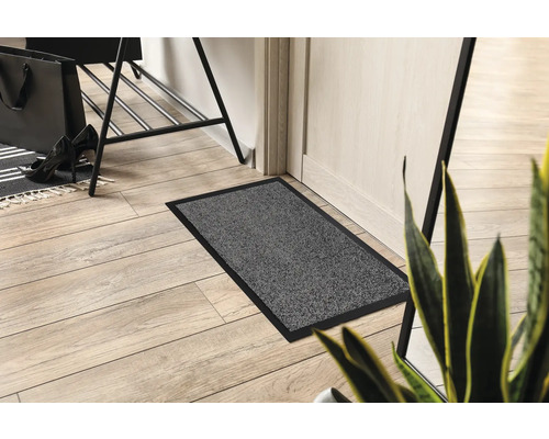 Šedá rohožka s černým okrajem ve vstupním prostoru.