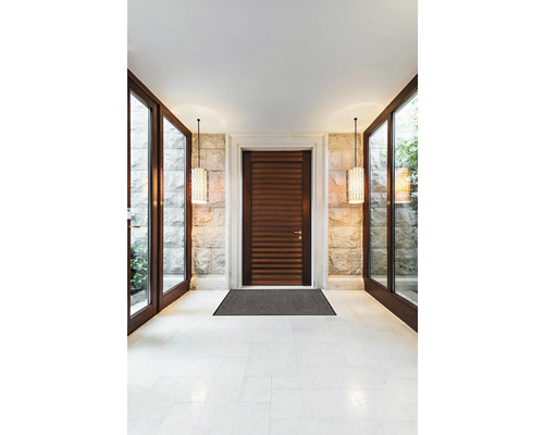 Vstupní prostor s dřevěnými dveřmi, rohožkou, kamennou stěnou a závěsnými lampami