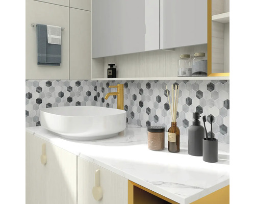 Světlá koupelna s umyvadlem, baterií a mozaikovými obkladačkami ve tvaru šestiúhelníků