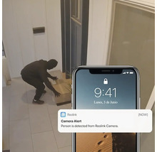 Upozornění z bezpečnostní kamery na displeji smartphonu, v pozadí osoba krade balíček.