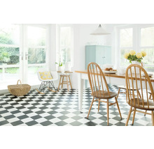 Světlá místnost s šachovnicovou podlahou, jídelním stolem a židlemi