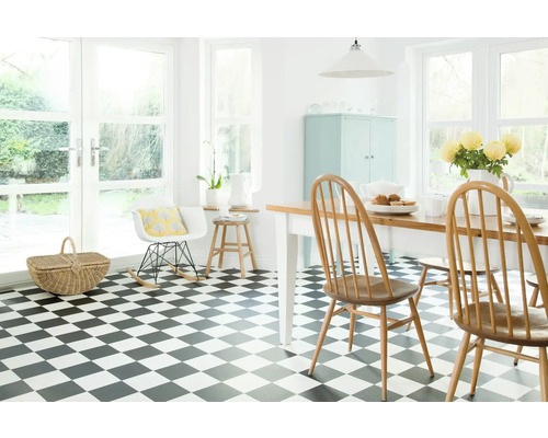 Světlá místnost s šachovnicovou podlahou, jídelním stolem a židlemi