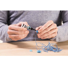 Osoba lepí sluchátka vteřinovým lepidlem.