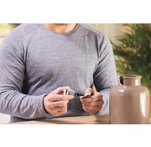 Muž opravuje keramickou vázu lepidlem