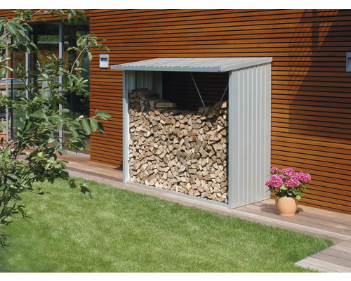 Kovový sklad dřeva plný palivového dříví na zahradě