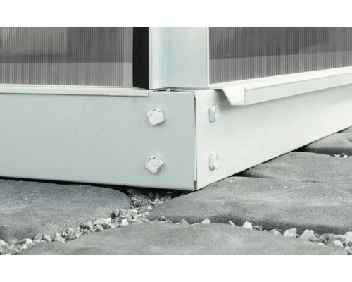 Detailní pohled na kovový rám skleníku s polykarbonátovými deskami a šrouby