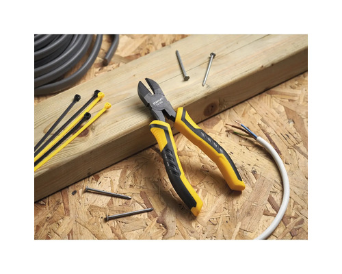 Boční štípací kleště s kabelovými svazky, hřebíky a kabelem na dřevěném pozadí