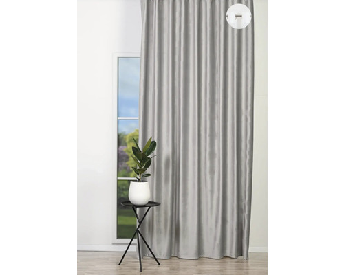 Šedý závěs vedle okna s malým stolem a pokojovou rostlinou