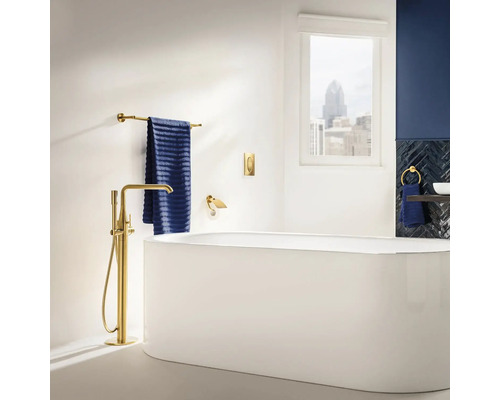 Koupelna s volně stojící vanou, baterií, ručníkem a doplňky