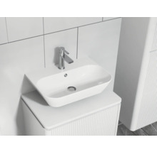 Moderní koupelnové umyvadlo s baterií na skříňce se žebrovanou strukturou.