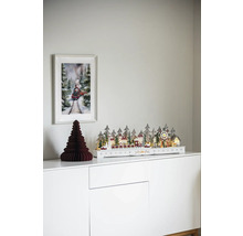 Dekorativní vánoční scéna s osvětlenou zimní krajinou, papírovým stromem a obrázkem vlaku na bílé skříňce