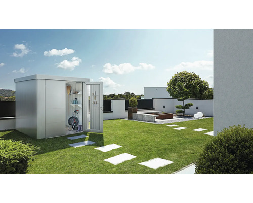 Kovová zahradní skříň s otevřenými dveřmi na trávníku