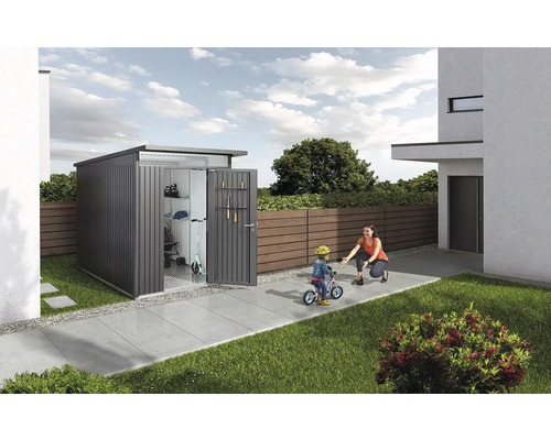 Moderní zahradní domek na nářadí na zahradě s otevřenými dveřmi a hrající si rodinou.