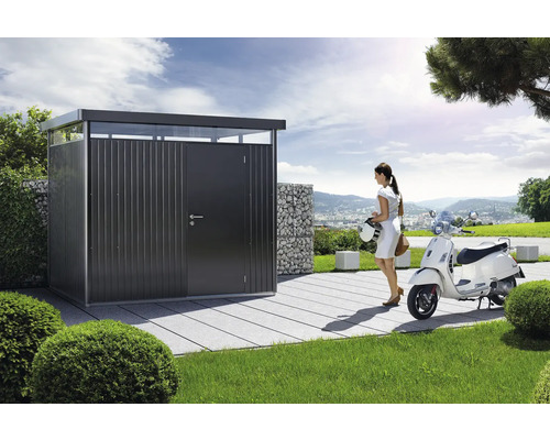 Kovový zahradní domek s ženou a skútrem na zahradě