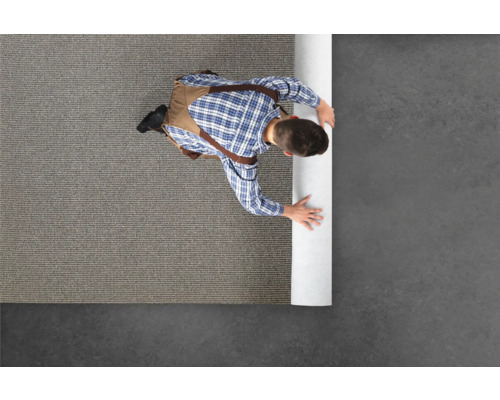 Řemeslník rozbaluje koberec.