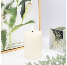 Dekorativní LED sloupková svíčka s malbou v pozadí a mramorovaným svícnem.