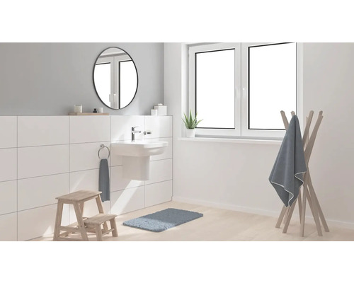 Světlá koupelna s umyvadlem, zrcadlem, oknem a věšákem na ručníky