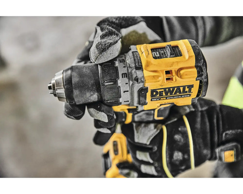Detail akumulátorové vrtačky DeWalt v ruce řemeslníka v pracovních rukavicích