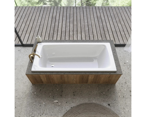 Vestavěná vana v moderně navržené koupelně s dřevěnou podlahou a kamennou podlahou