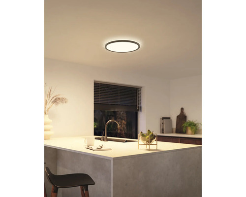 Moderní kuchyně s kulatým stropním svítidlem, které vytváří světlou a příjemnou atmosféru.