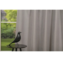 Dekorace s ptákem na stole před oknem se závěsem