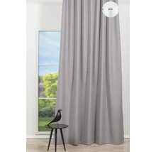 Pohled na šedý závěs před oknem s ozdobnou figurkou na stole