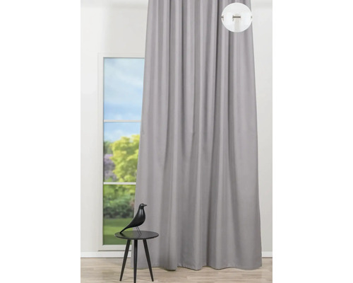 Pohled na šedý závěs před oknem s ozdobnou figurkou na stole