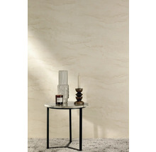 Dekorativní zátiší se svíčkou, vázou a vonnou svíčkou na odkládacím stolku před vzorovanou stěnou