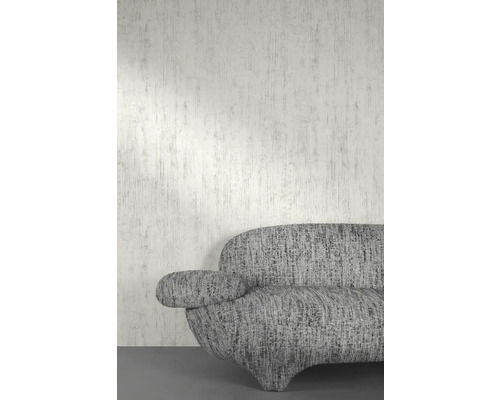 Detail šedé pohovky u zdi